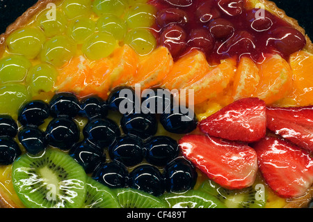 Colorate torta di frutta con uva, fragole, kiwi, i mandarini e le ciliegie di pasticceria come dessert Foto Stock