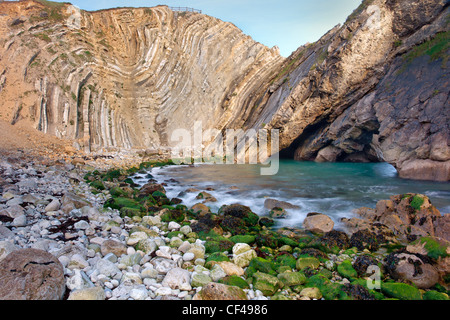 Mare moto vorticoso in ed intorno a rocce nel foro di scale, una relativamente nuova cove che è la formazione di appena a ovest di Lulworth Cove nel Dorse Foto Stock