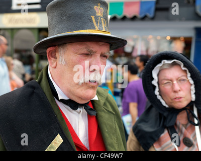 Un uomo e una donna vestita di capi di abbigliamento in stile Vittoriano al Dickens Festival di Rochester. Foto Stock