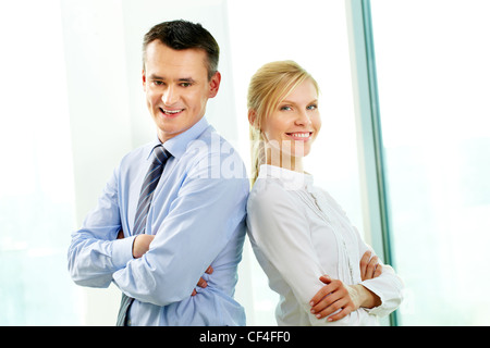 Due partner di fiducia in piedi di schiena e sorridente Foto Stock
