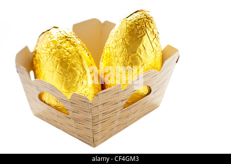 Due di lamina di oro più semplice di cioccolato uova in una cestella di cartone Foto Stock