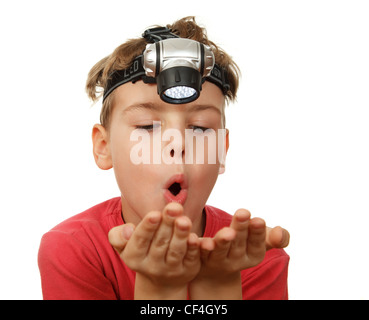 Ritratto di ragazzo con la torcia elettrica sulla sua testa su sfondo bianco. Emanava sulle sue mani. Foto Stock