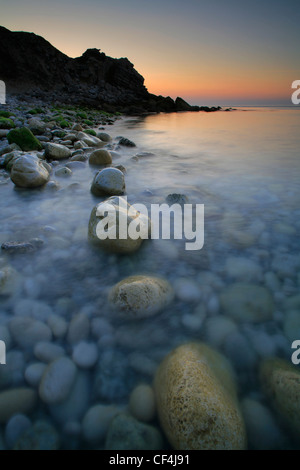 Sunrise oltre la spiaggia appartata in chiesa Ope Cove su Jurassic Coast sull'isola di Portland. Foto Stock