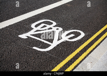 Contrassegni per pista ciclabile e doppio giallo linee su tarmaced road Foto Stock