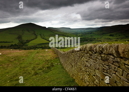 Un secco muro di pietra che conduce verso perdere la collina nel Parco Nazionale del Peak District. Foto Stock