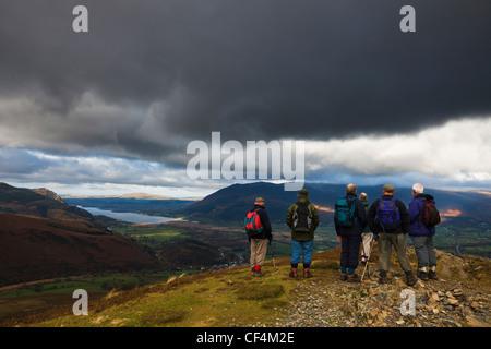 Un gruppo di escursionisti senior permanente sulla sommità di Barrow nel distretto del lago che guarda verso il lago di Bassenthwaite. Foto Stock