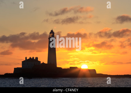 Silhouette di St Mary's Faro (non funziona più come un faro) vicino a Whitley Bay a sunrise. Foto Stock