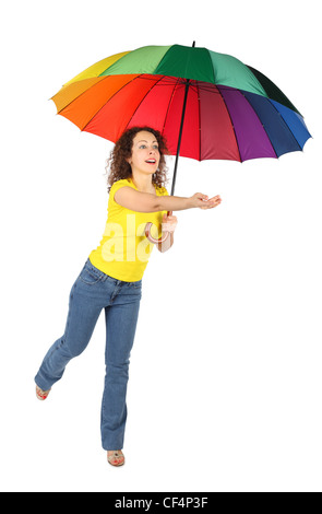 Giovane bellezza donna in maglia gialla con ombrello multicolore jumping con raggiunto una mano isolato su bianco Foto Stock