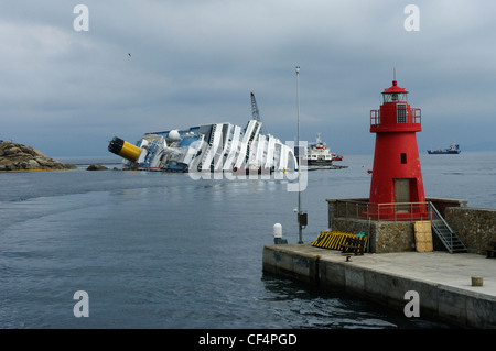 Costa Concordia giacente sul suo lato di fianco all'Isola del Giglio, Arcipelago Toscano, Italia, visto dal porto dell'isola Foto Stock