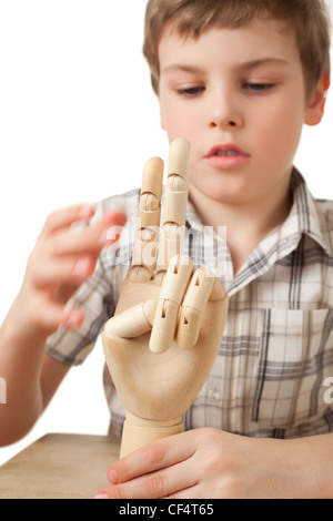 Il ragazzo è giocato dalla mano di legno del manichino isolati su sfondo bianco Foto Stock