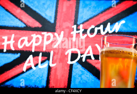 Blackboard pub segno con un gesso disegnato union jack, che recita "happy hour tutti i giorni' e una pinta bicchiere di birra in primo piano Foto Stock