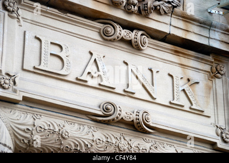 Vecchio scolpita in pietra " Banca " segno sull'esterno dell'edificio. Foto Stock