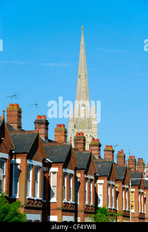 La guglia di Norwich Cathedral affacciato su una fila di case a schiera. Foto Stock