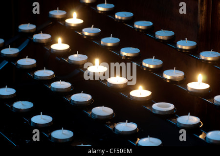 Il tè luce preghiera candele in una chiesa Foto Stock