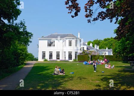 Famiglie relax su un prato da Pembroke Lodge, una dimora georgiana a Richmond Park. Foto Stock