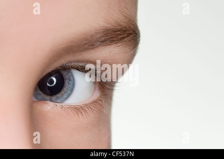 Sinistro occhio blu del bambino close up isolati su sfondo bianco Foto Stock