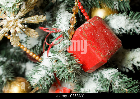 Regalo celebrativa in rosso le piccole scatole appeso sul Natale pelliccia-tree Foto Stock