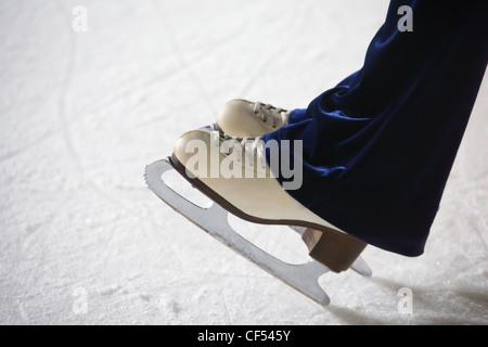 Piedi umani in manie in piedi sul ghiaccio sull orlo di un bordo sulla pista di pattinaggio Foto Stock