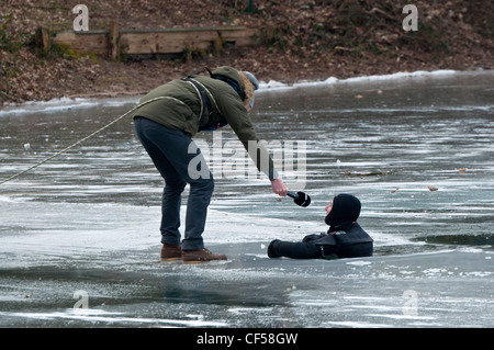 L'uomo essendo intervistato durante una vita pratica di risparmio sul lago ghiacciato in Germania. Foto Stock