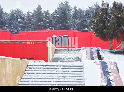 Parco e parete rossa con pietra scultura della famiglia memorial e scalini in pietra incendi intorno Foto Stock