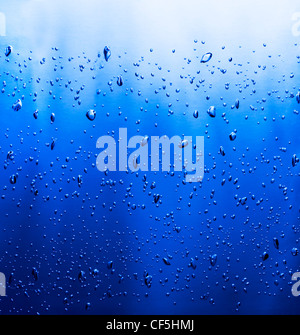 Vista laterale di bollicine d'aria in un liquido di colore blu. Square shot. Foto Stock