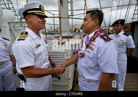 (Da sinistra a destra) il capitano della marina degli Stati Uniti Jeffrey James Joint base il comandante Pearl Harbor-Hickam, dà una moneta al CMdR della marina indonesiana. Haris Bima della nave alta della Marina Indonesiana, KRI Dewaruci alla base congiunta Pearl Harbor-Hickam, Hawaii. Il KRI Dewaruci, arrivato a JBPHH il 29 febbraio 2012, per una breve visita al porto mentre si perviene sulla terraferma degli Stati Uniti. Dewaruci ha iniziato la sua crociera da Surabaya, Giava Est, Indonesia il 14 gennaio, come parte dell'operazione Internazionale Sail (OpSail) 2012 per commemorare il bicentenario della guerra del 1812. Foto Stock