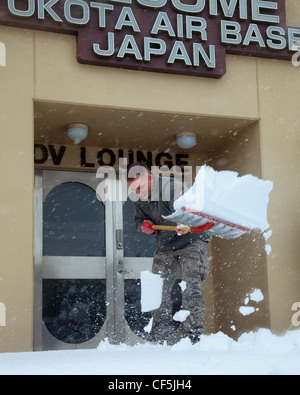 Jeremy Stowers, 374th Operations Support Squadron, pale neve per pulire il marciapiede di fronte alla sala visitatori, 29 febbraio 2012 presso la base aerea di Yokota, Giappone. Otto e mezzo centimetro di neve cadde in quindici ore, inducendo la leadership di base a richiamare gli aratri per liberare la pista, i tassiway e le carreggiate. Secondo il 374th Operations Support Squadron volo meteorologico, la nevicata è stata causata da un'abbondanza di umidità da 'Shanghai Low', il sistema a bassa pressione che si muove di solito lungo la costa meridionale del Giappone. Foto Stock