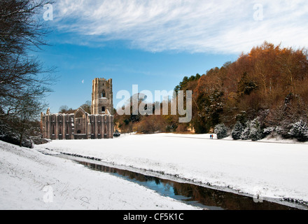 La neve che copre il terreno intorno al XII secolo le rovine di Fountains Abbey, il più grande rovine monastiche in Inghilterra. Foto Stock
