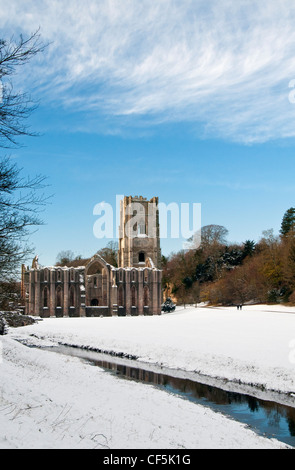 La neve che copre il terreno intorno al XII secolo le rovine di Fountains Abbey, il più grande rovine monastiche in Inghilterra. Foto Stock