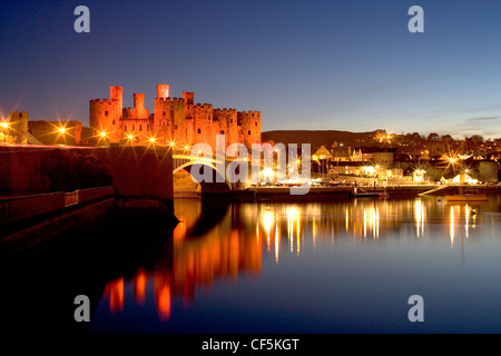 Una vista di Conwy Castle al tramonto da oltre il fiume. Il castello è stato una parte importante del re Edward I piano di Wale circostante Foto Stock