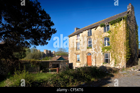 Una vista di una vecchia casa di pietra e Laugharne castello. Laugharne è un antica cittadina sul fiume Taf, che consiste di un mixtur Foto Stock