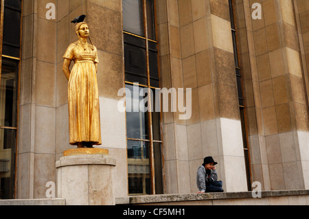 Statua al Palaise de Chaillot con piccolo ragazzo seduto accanto a bird e sulla parte superiore della figura Foto Stock