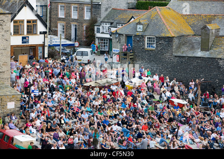 La folla in Port Isaac, Cornwall, guardando il Fisherman's amici shanty cantanti sulla spiaggia Foto Stock