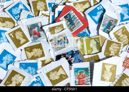 Un assortimento di usato francobolli britannici. Foto Stock