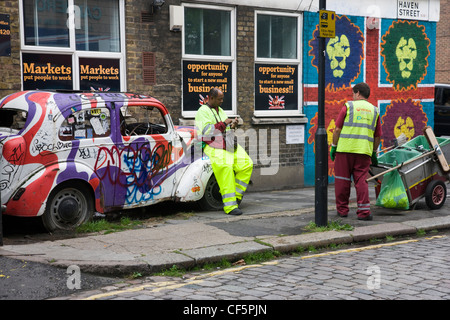 Pulitori di strada prendendo una pausa di Camden Town, Londra Foto Stock