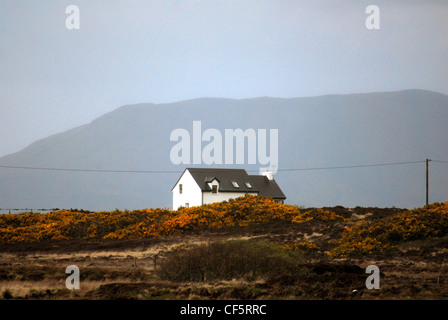Una vista verso una casa colonica solitario e montagne vicino Doo Lough nella contea di Mayo. Foto Stock