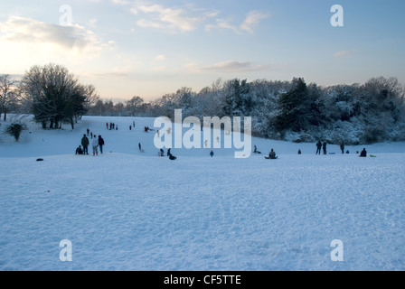 Le persone che si godono la coperta di neve piste a Epsom Downs. Foto Stock