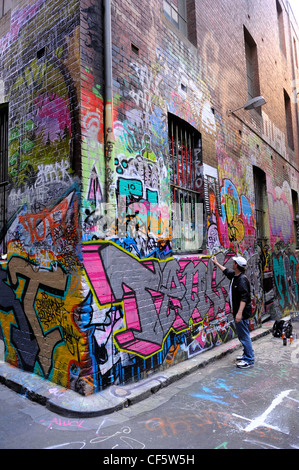 Graffiti artist spruzzatura sulla parete, Hosier Lane, Melbourne, Victoria, Australia Foto Stock