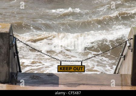 Segno e la catena impedendo l'accesso alla spiaggia di alta marea a Blackpool. La città è creduto di ottenere il suo nome da un drenaggio ch Foto Stock