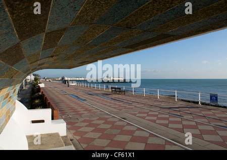 Una vista del lungomare di Hastings da sotto un riparo con posti a sedere in East Sussex. Foto Stock