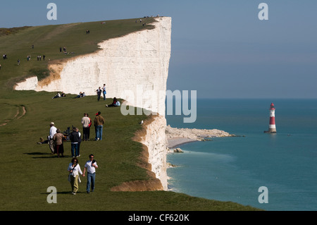 La gente camminare lungo la precaria in cima alla scogliera di Beachy Head sulla East Sussex costa. Foto Stock