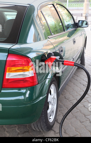 Pompa di rosso per il rifornimento di carburante il riempimento verde auto sulla stazione, estate, vista dal retro Foto Stock