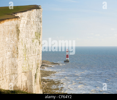 Beachy Head Lighthouse alla base della scogliera, il più alto di chalk scogliera sul mare in Gran Bretagna. Foto Stock