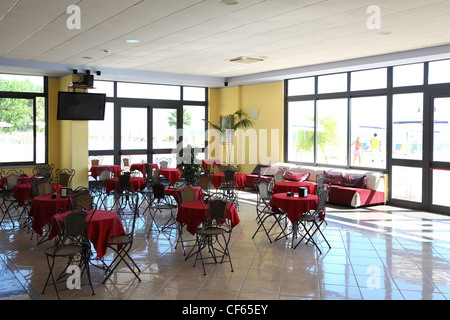 Piccola cena-carri con red tovaglie e forgiato sedie stand in hotel con televisore e divano Foto Stock