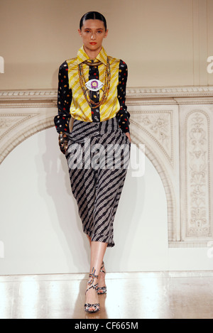 Duro Olowu London Fashion Week pronto a indossare Primavera Estate modello indossando il giallo e il nero modellato a maniche lunghe Camicia di seta e Foto Stock