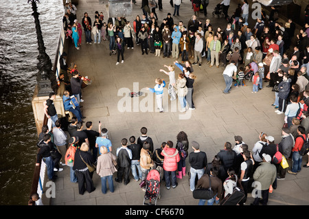 Un gruppo di ragazze che ballano la musica suonata da artisti di strada sulla banca del sud. Foto Stock