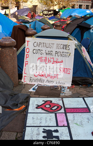 Anti capitalismo banner visualizzato in tende da campeggio da occupare del London Stock Exchange manifestanti di fronte St.Paul Cathedral. Foto Stock