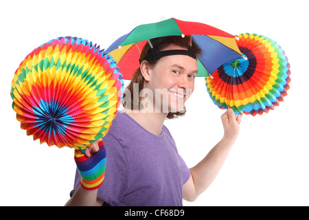 Ritratto di uomo felice con il rainbow hat ombrello sulla testa e colorfull ghirlanda di carta nelle mani Foto Stock