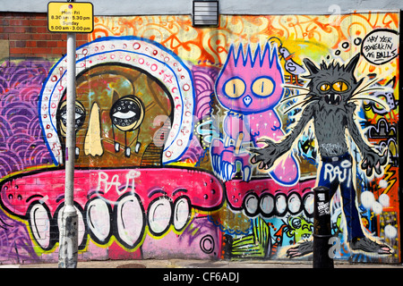 Un array di caratteri graffiti su un muro in Brick Lane. Foto Stock