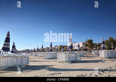 Sdraio e ombrelloni sono accuratamente costruito righe in mattinata sulla spiaggia Foto Stock